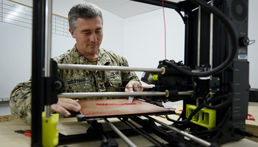 A Military service member working with a machine on a workbench