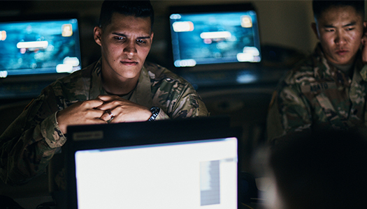 Two Military service members sitting inside a control room