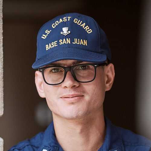 Man in U.S. Coast Guard uniform smiling and facing towards the camera